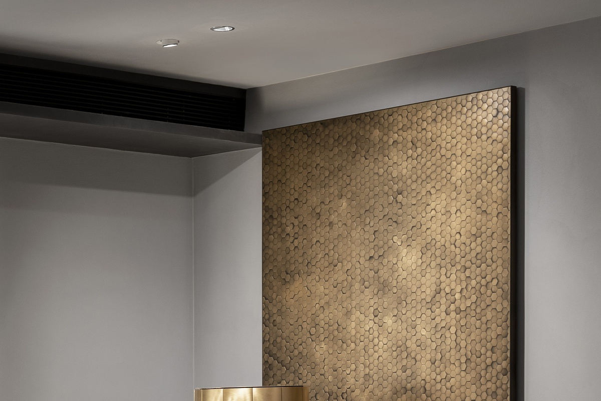 ERCO Optec spotlights illuminate a gold wall in the De Castelli showroom, Beijing.