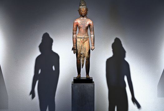 Directional light highlights a statue, accentuated by LED spotlights, casting shadows.
