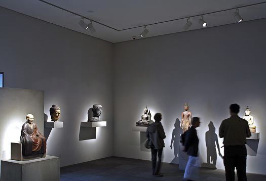 Directional light accentuates Buddha statues in a museum, illuminated by ERCO spotlights.