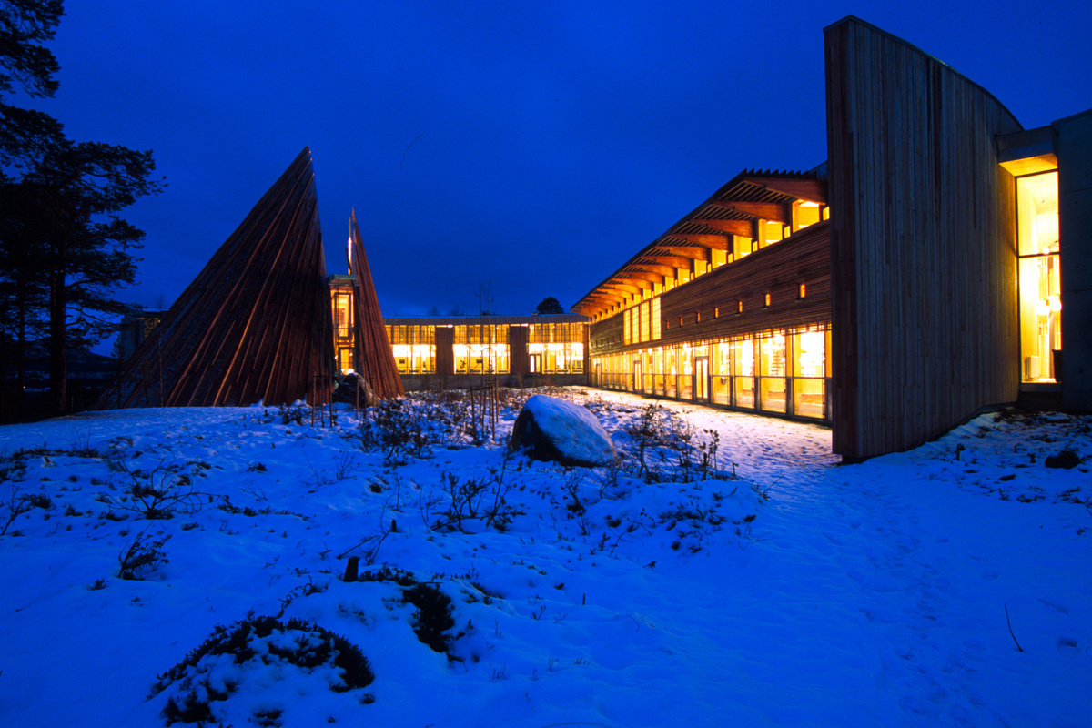 Architectural building with ERCO lighting in snow, nighttime exterior view.