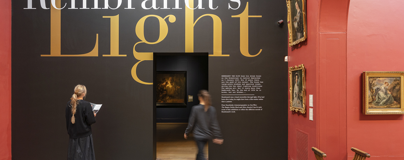 Visitors at Dulwich Picture Gallery viewing the 'Rembrandt's Light' exhibit lit by ERCO LED spotlights.