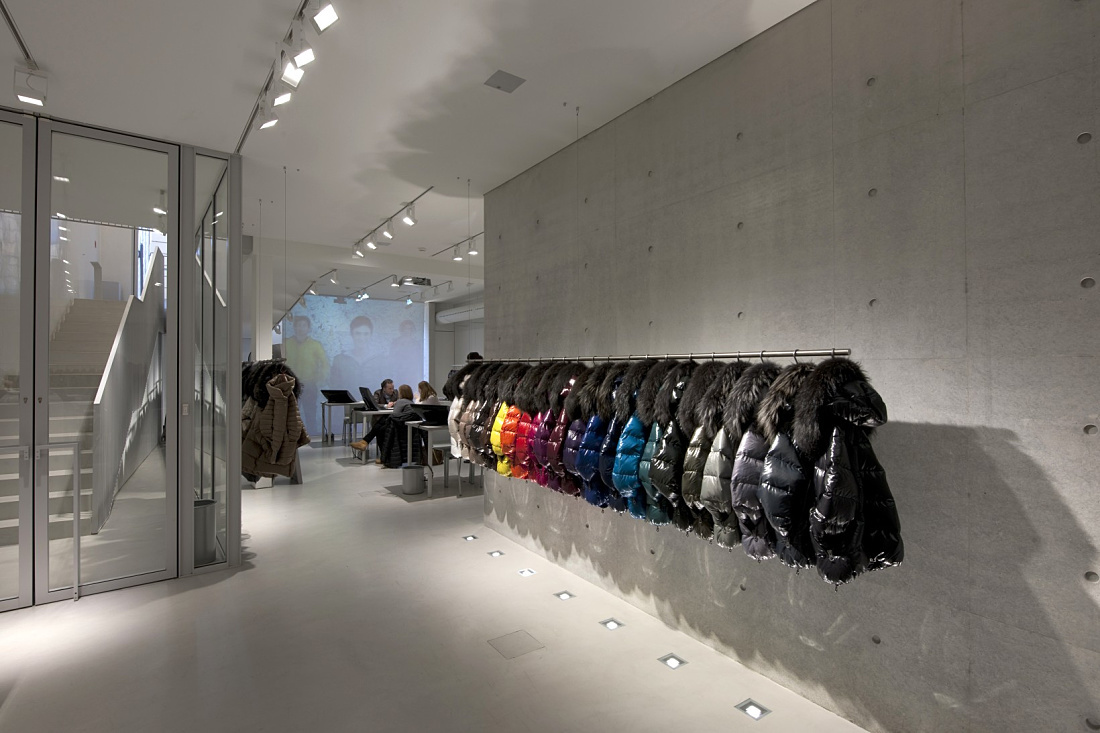 Duvetica showroom featuring colorful down jackets illuminated by ERCO LED lighting.