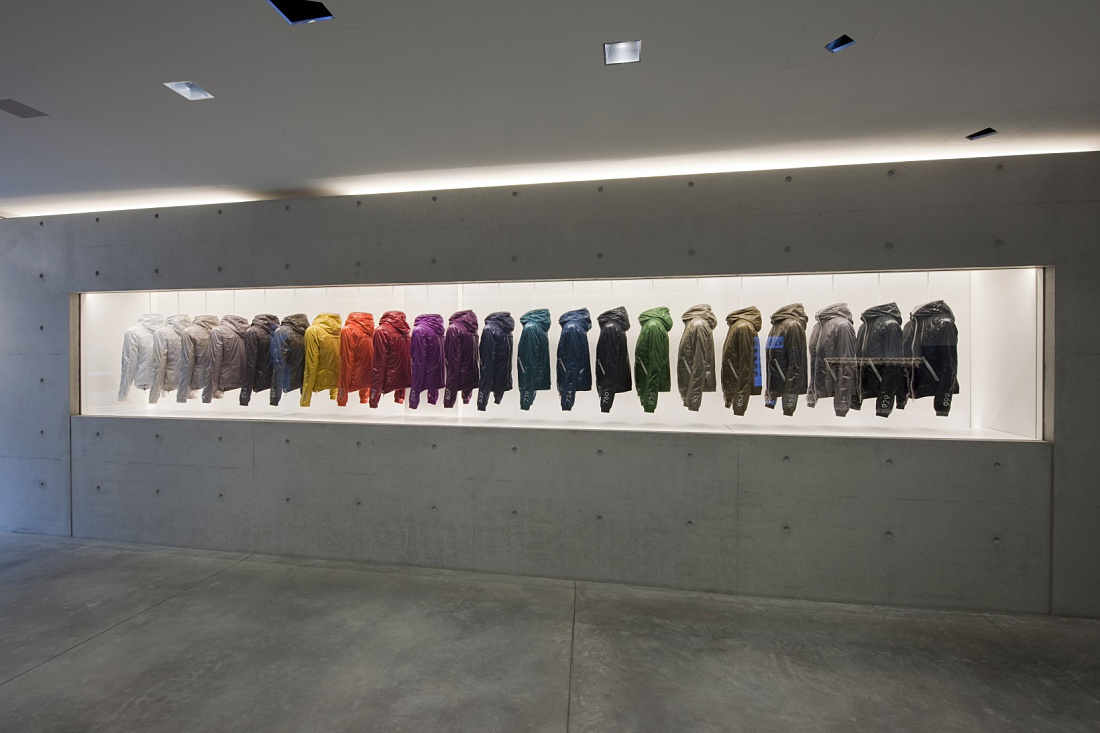 Duvetica down jackets in a minimalist showroom, illuminated by ERCO LED lighting.