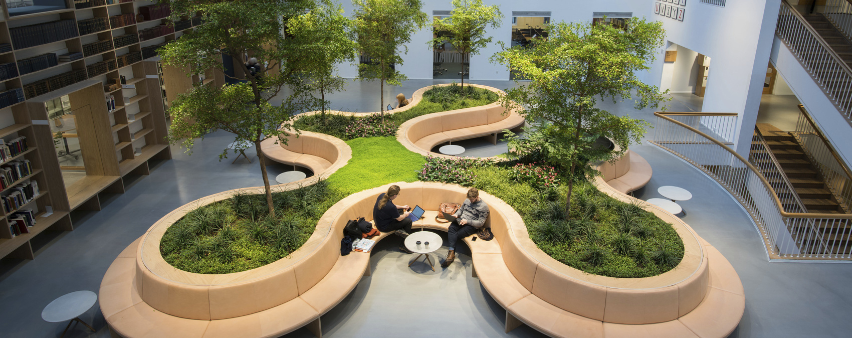 Indoor space featuring seating and greenery, promoting a comfortable and sustainable atmosphere.