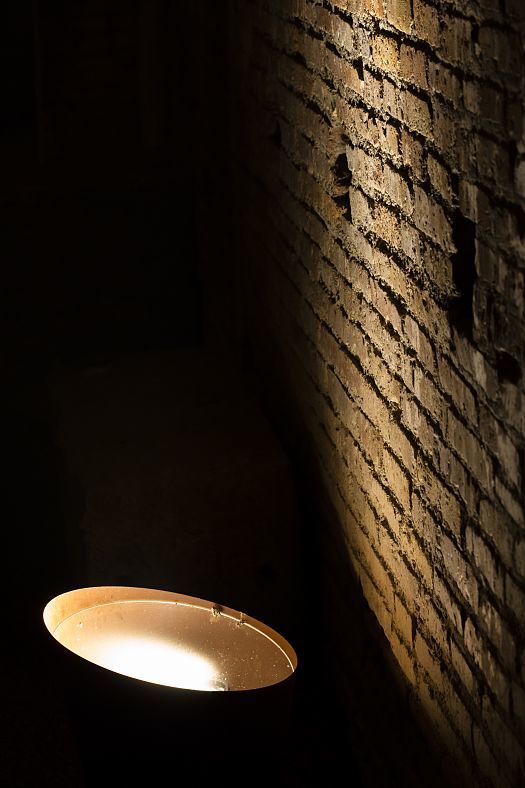 ERCO Kona projector illuminating a brick wall in Domus Aurea, Rome. Atmospheric accent lighting of ancient architecture.