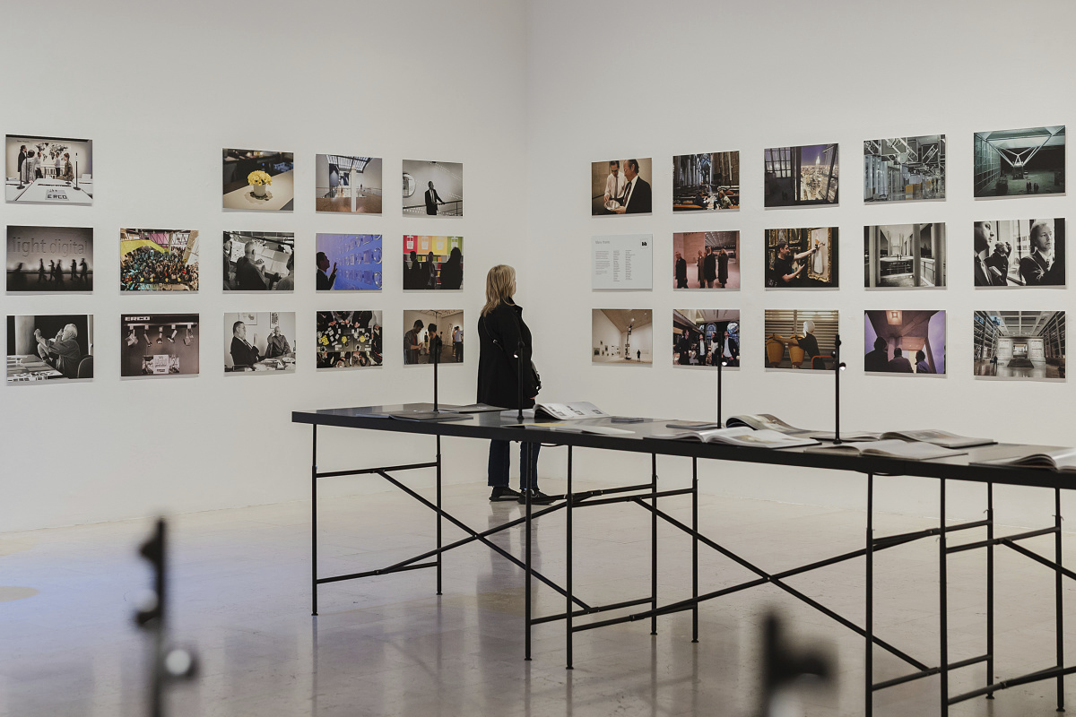 Visitor views the ERCO Light Box exhibit in Milan, showcasing light and architecture through photography.