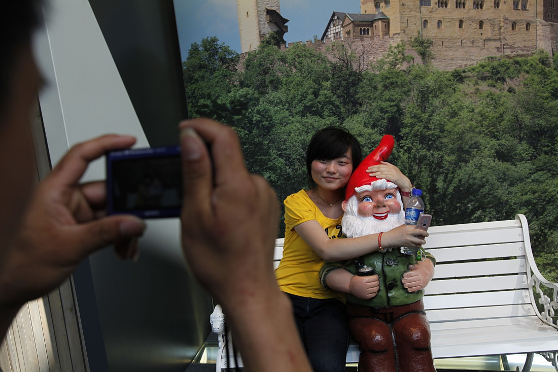Visitor photographs a garden gnome in front of a castle backdrop at the German Pavilion, Expo Shanghai 2010.