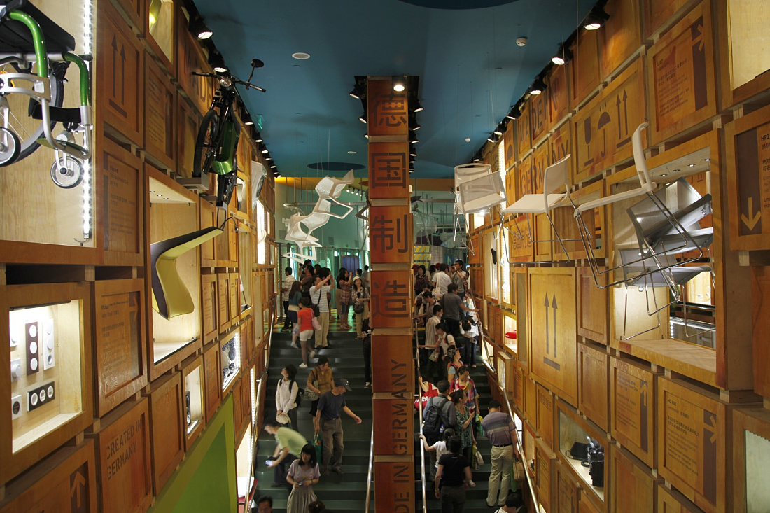 German Pavilion Shanghai Expo 2010: Visitors on stairs amidst exhibits in crates.
