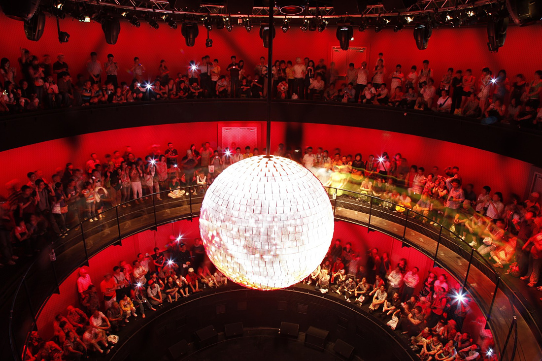 German Pavilion Shanghai: Illuminated disco ball with ERCO lighting and visitors.