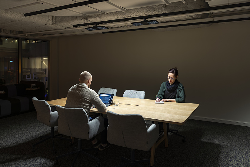 ERCO Jilly downlights illuminate a conference table in a modern Fabege office in Stockholm.