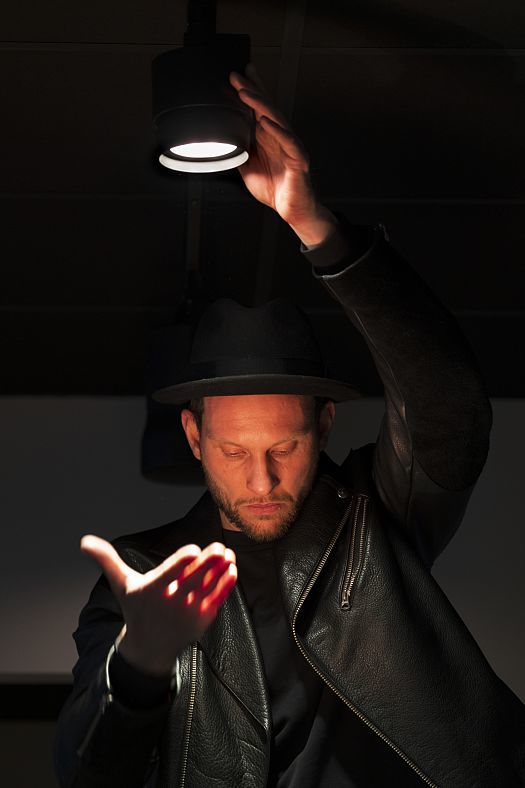 Man adjusting an ERCO Jilly downlight, showcasing flexible office lighting in Stockholm.