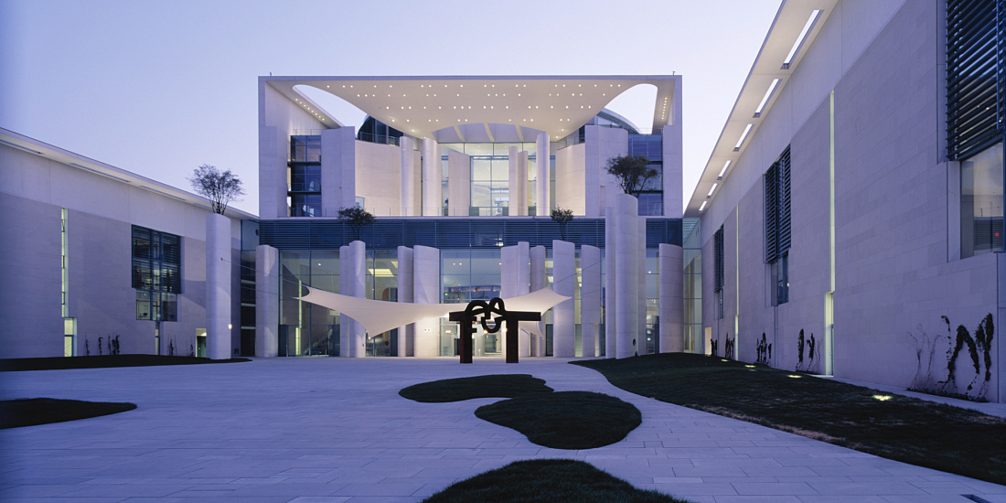 Beleuchtete Fassade des Bundeskanzleramtes in Berlin mit Kunstwerk im Hof.
