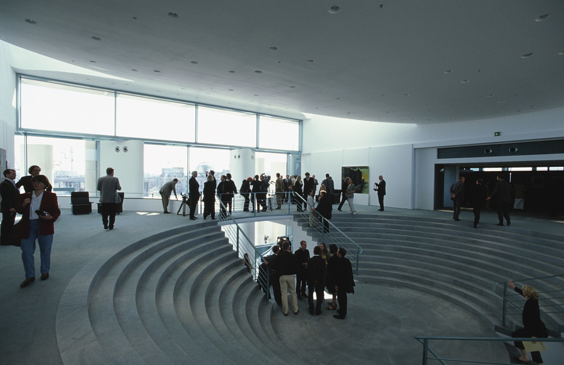 Interior of the Federal Chancellery, showing people on stairs and ample daylight.