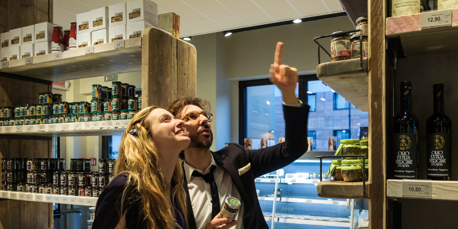Customers in Fiorital delicatessen, Padua, illuminated by ERCO LED lighting.