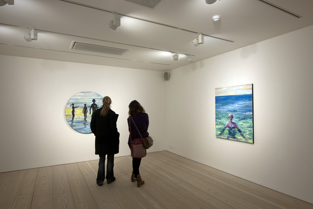 Visitors viewing art illuminated by ERCO LED spotlights in Forsblom Gallery.