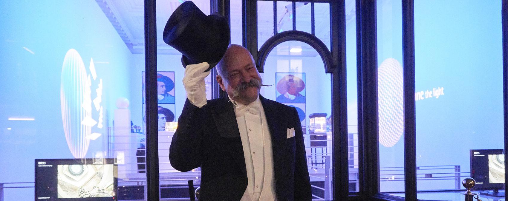 Man in tuxedo with top hat at ERCO's London showroom.
