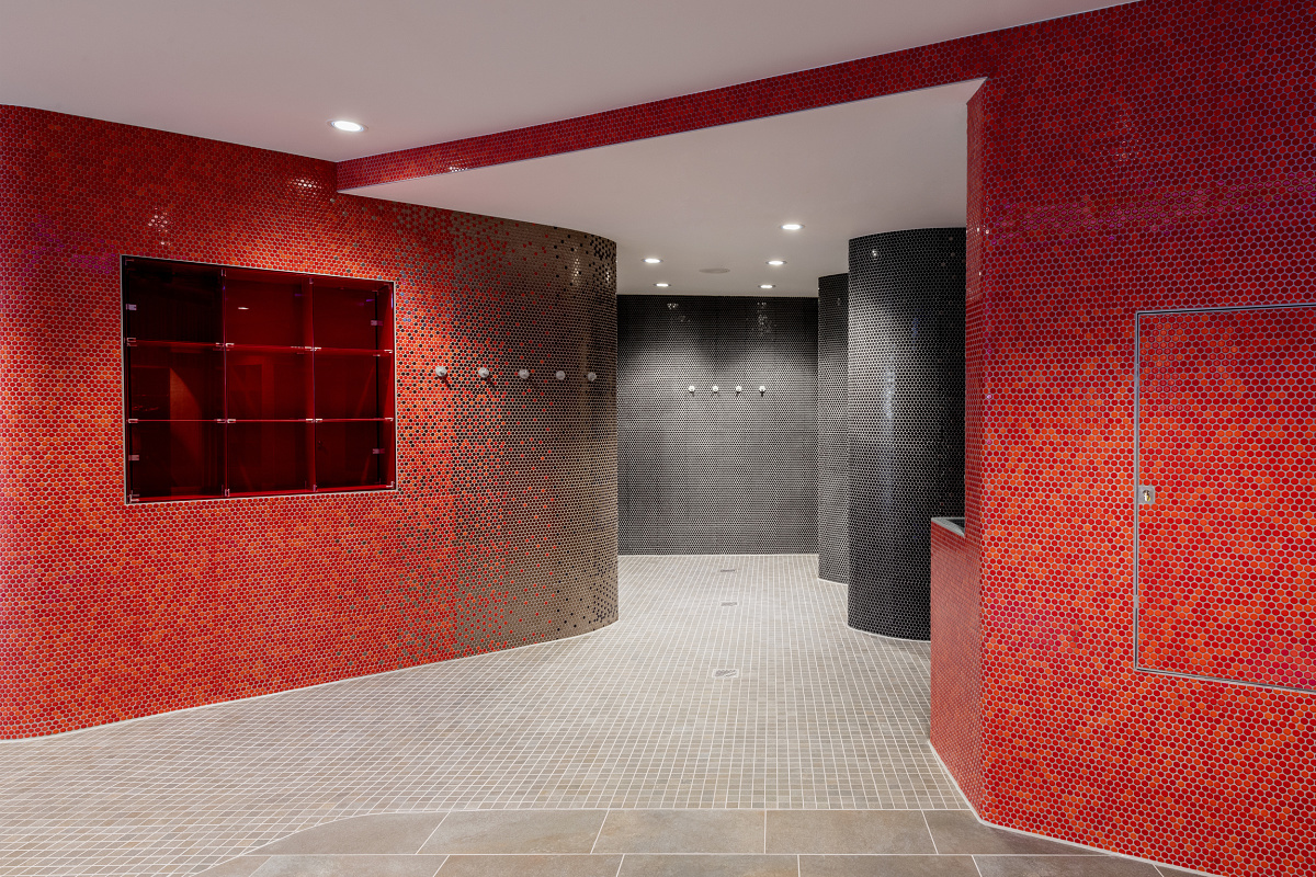 Interior of Friedrichshafen sports pool with ERCO lighting and red mosaic tiles.