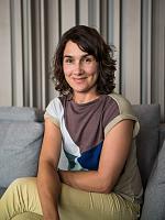 Portrait of a woman sitting on a sofa, featuring natural lighting and a relaxed atmosphere.