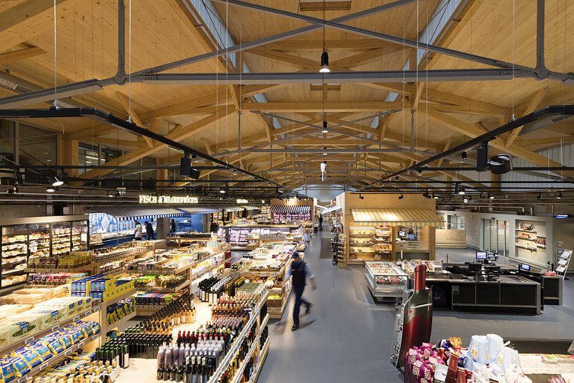 FrischeParadies Stuttgart market hall featuring ERCO LED spotlights accentuating the gourmet food selection.
