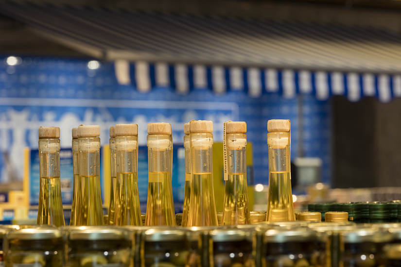 Gourmet oils in glass bottles with corks at FrischeParadies Stuttgart, lit by ERCO LED spotlights.