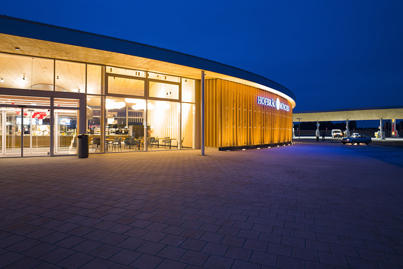 Illuminated Fürholzen petrol station on the A9 with inviting shop and restaurant, designed with ERCO lighting.