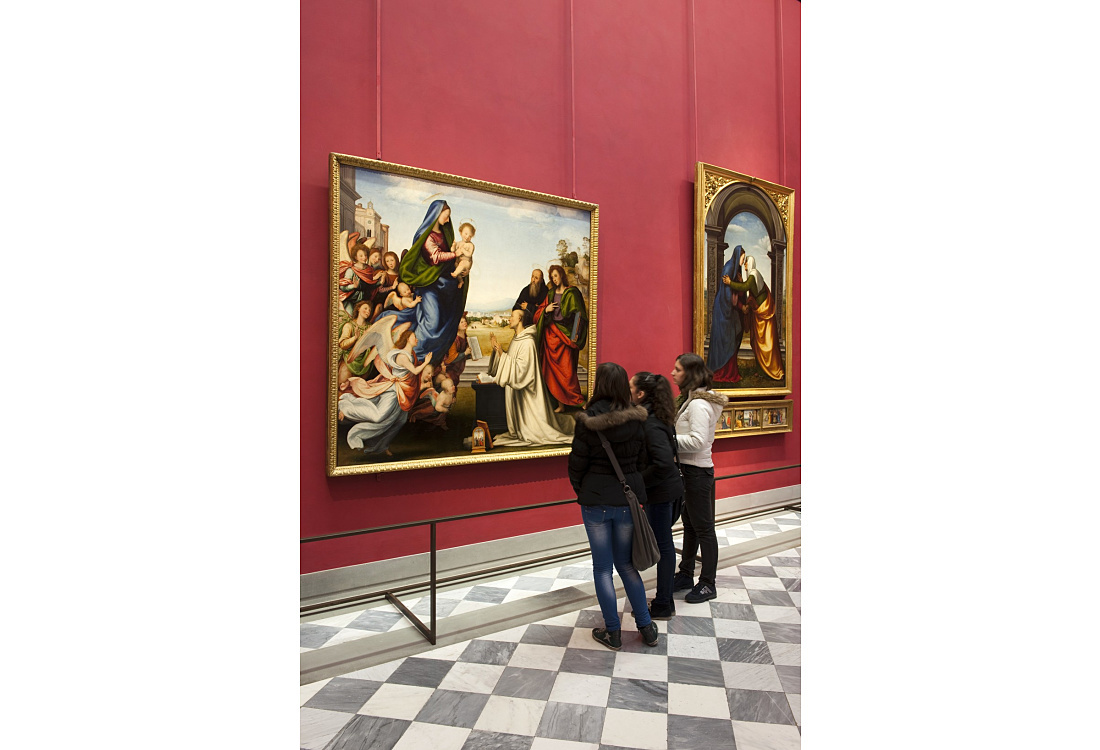 Visitors viewing Renaissance paintings at the Uffizi Gallery, Florence. Museum lighting.