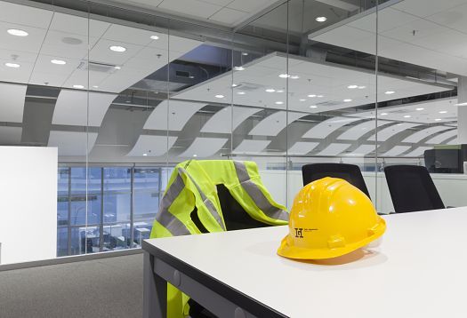 Yellow hard hat and safety vest in Gebrüder Heinemann office, Hamburg. ERCO LED downlights for efficient office lighting.