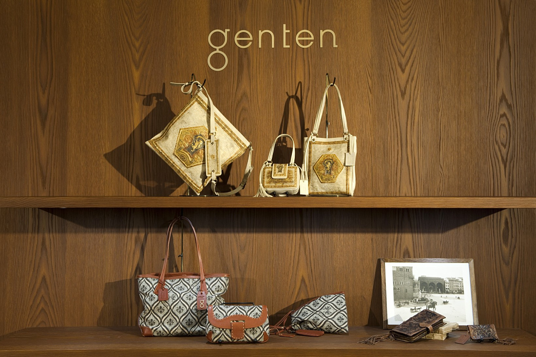 Genten Shop in Florence: Display of handbags and accessories on wooden shelves with soft LED lighting.