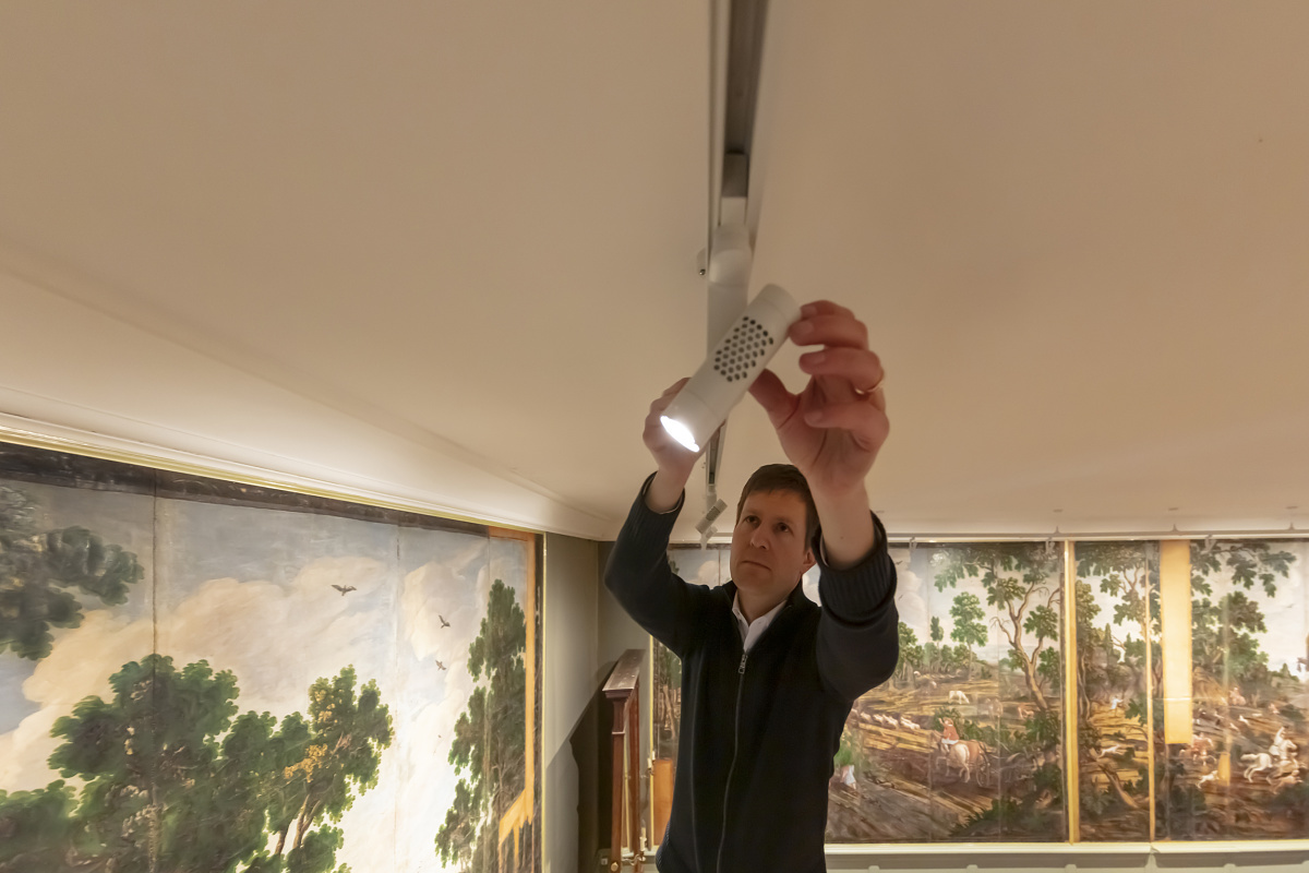 A man adjusts an ERCO Eclipse spotlight on a track at Glücksburg Castle.