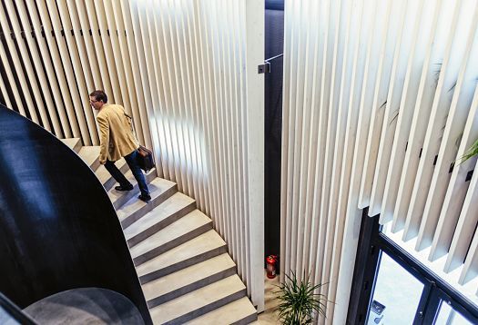 Man on stairs in Graficas Varias with ERCO LED lighting. Modern design with focus on light.