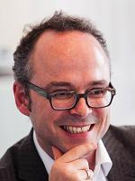 Portrait of Martin Krautter, ERCO freelance author, wearing glasses and smiling.