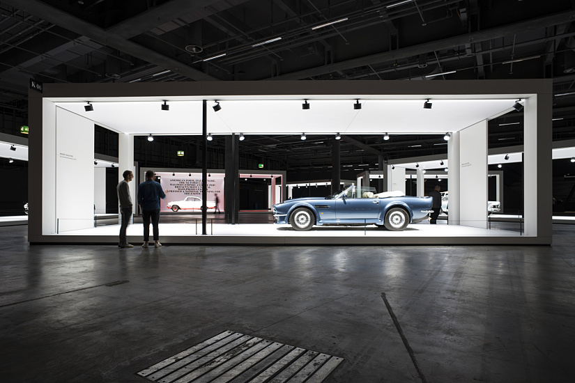 Grand Basel classic car show: Blue vintage convertible under ERCO lighting in a white display frame.