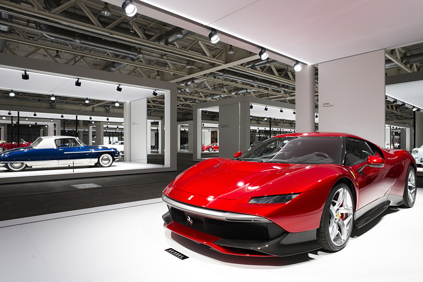 Red Ferrari sports car at the Grand Basel exhibition, illuminated by ERCO spotlights.