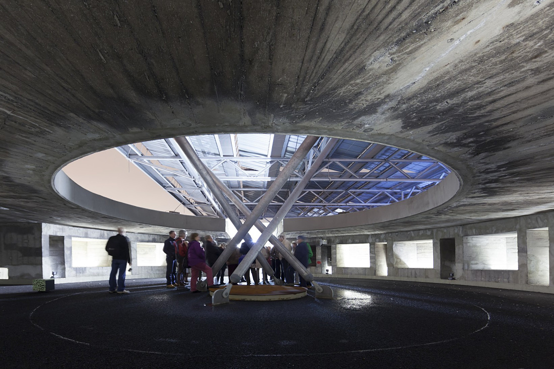 Interior of Hamburgs Energy Bunker with visitors and skylight, letting daylight in.