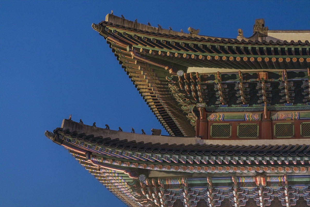 Detailed view of Gyeongbokgung Palace's pagoda roof architecture, illuminated by ERCO lighting.
