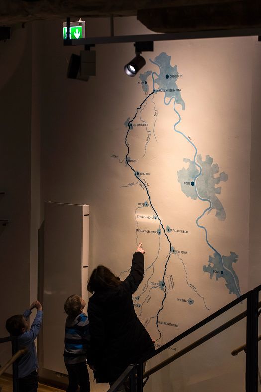 Children view the river map at KM 51 – Erftmuseum, illuminated by ERCO LED spotlights.