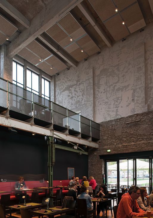 Halle 32 restaurant in Gummersbach, featuring ERCO Optec spotlights highlighting industrial architecture.