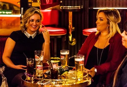 Women enjoying drinks at the atmospheric Harp Bar, Belfast, illuminated with ERCO LED lighting.
