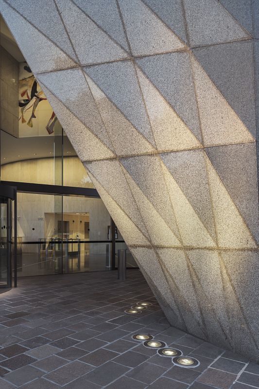 Illuminated facade of Shell House in Melbourne with ERCO Tesis in-ground luminaires.