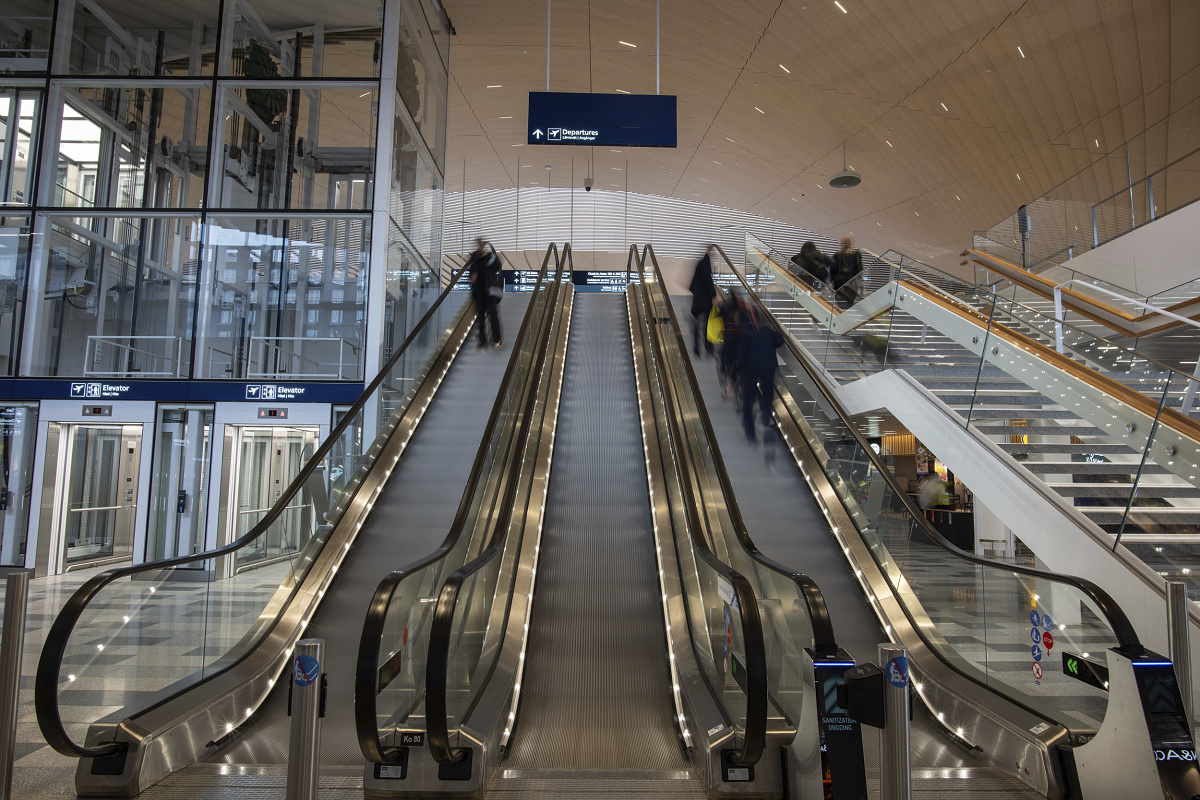 Escalators at Helsinki Airport featuring high-lumen ERCO LED lighting.
