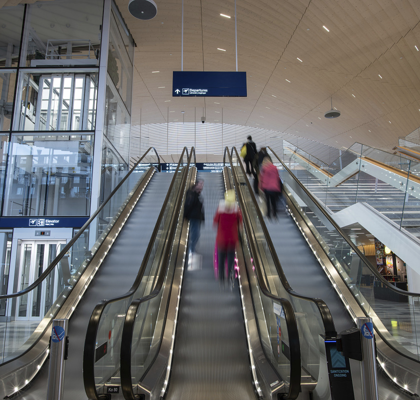 Helsinki Airport escalators with ERCO LED lighting leading to departures.