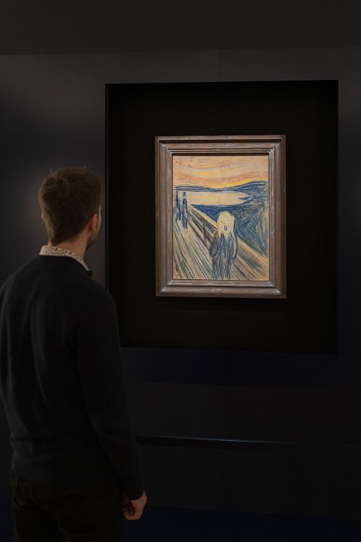 A visitor views Munchs The Scream illuminated by ERCO spotlights in the Munch Museum Oslo.