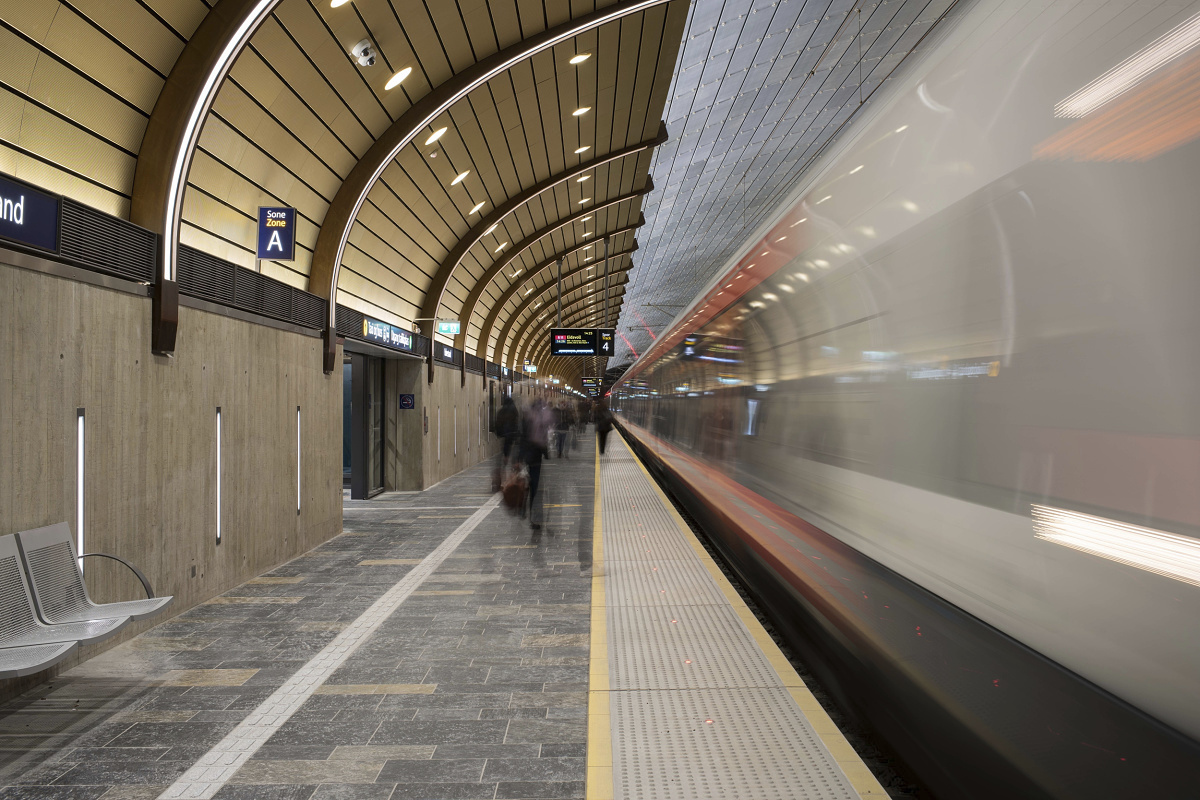 Holmestrand Station platform illuminated by ERCO downlights with a train in motion.