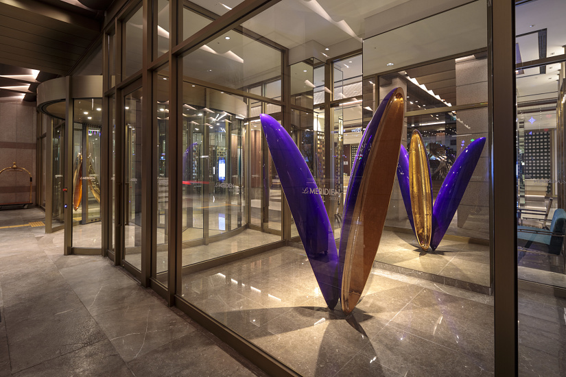 Le Méridien Seoul hotel entrance with art installation and revolving door, creating an inviting atmosphere with light.