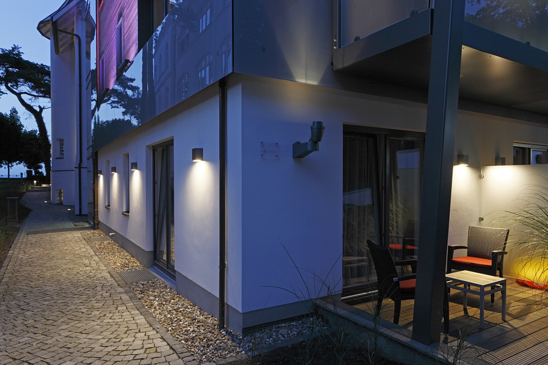 Hotel Nixe facade illuminated with ERCO Kubus wall luminaires and Beamer projectors for scenic lighting.