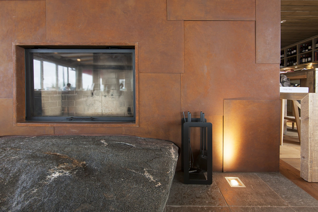 Fireplace area at Hotel Weissenhaus with Optec spotlights creating a warm ambiance.