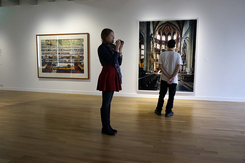 Visitors at Huis Marseille museum, Amsterdam, viewing photographs under ERCO LED lighting.