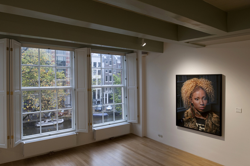 ERCO LED lighting at Huis Marseille Museum, Amsterdam, showcasing a portrait and canal view through windows.