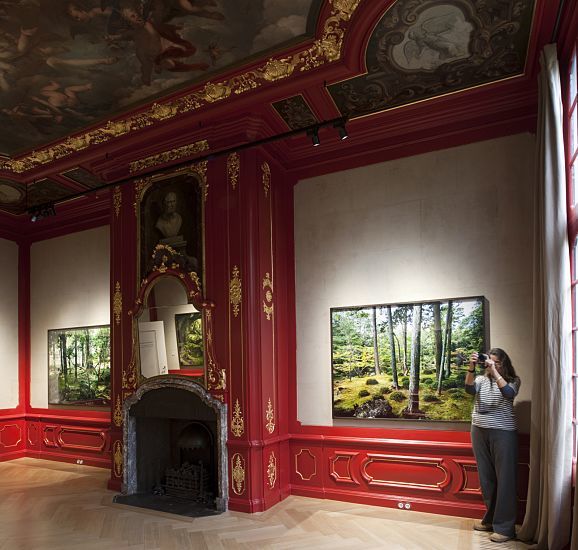 Photographer in Huis Marseille, Amsterdam, illuminated by ERCO LEDs, creating a cohesive atmosphere.