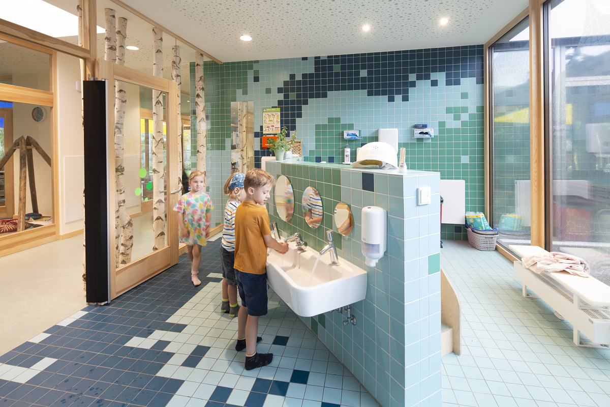 Children washing hands in the Rappelkiste Day Care Centers washroom, lit by ERCO LED lighting.